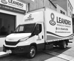 Caminhão baú Iveco da Leandro Mudanças e Transportes estacionado em frente à empresa, ilustrando o que conferir na garagem antes de contratar a mudança.